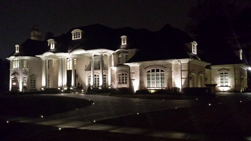 large home's facade lit by floodlights