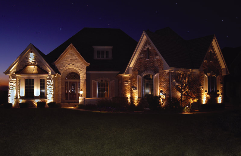 large home facade lit up in evening by front lights